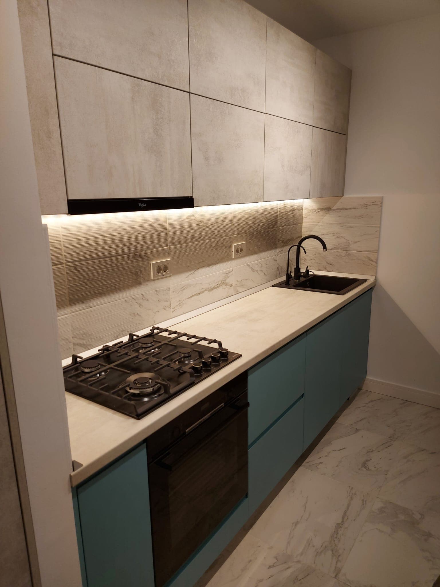 Compact kitchen with teal fronts and concrete-look cabinets, private residence Bucharest